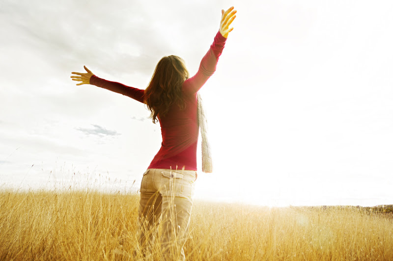 woman in field with sunset